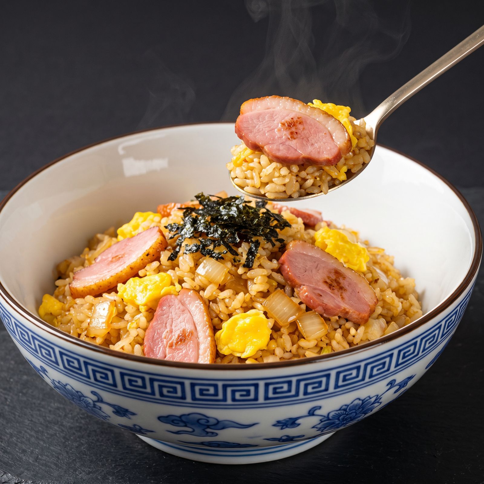 Smoked duck fried rice in a blue-and-white porcelain bowl, a spoonful lifted
